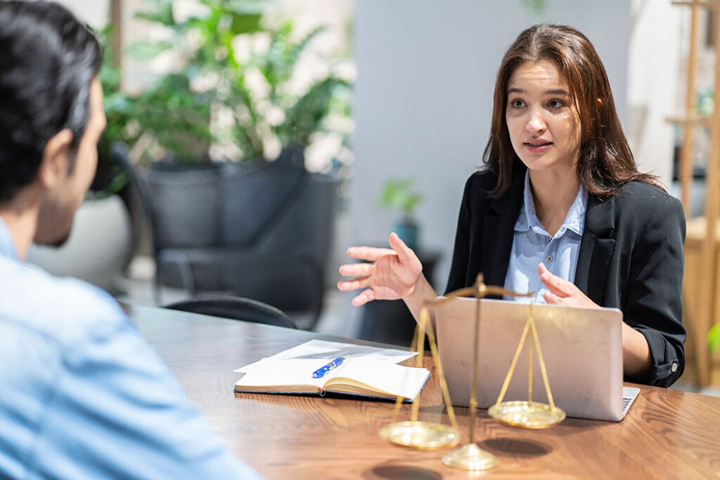 Female lawyer advises male business client on legal matters concerning a data breach. 