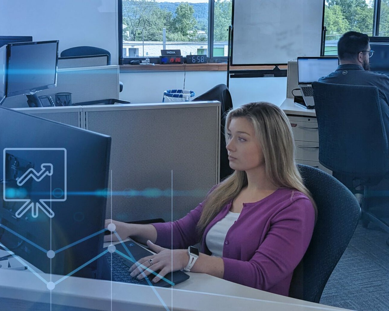 Young ProWriters Cyber Insurance agent wearing fuschia-colored blouse focuses intently on computer screen as she reviews insurance policies.