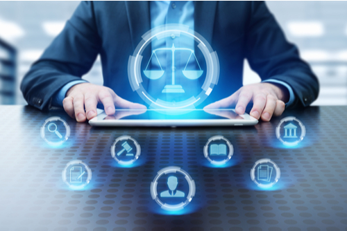 Labor law and lawyer concept, with man sitting at table as icons pop up in the air over tablet. 