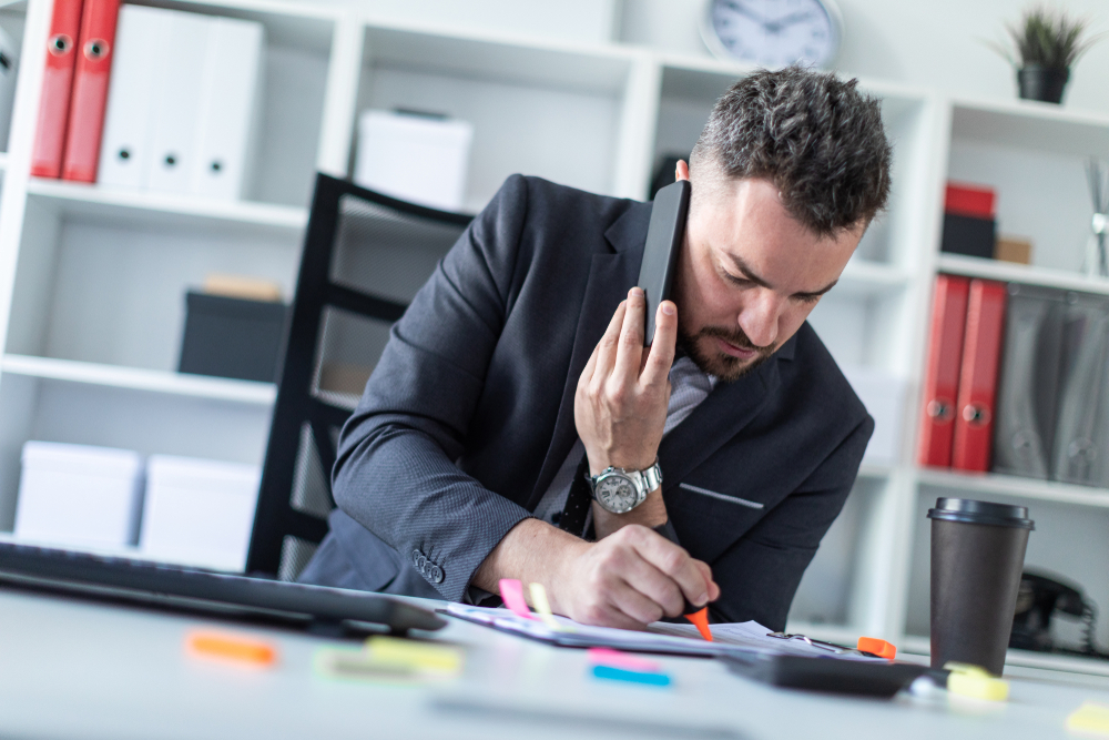  Insurance agent talks to client on mobile phone about ways to lower Cyber Insurance rates. 