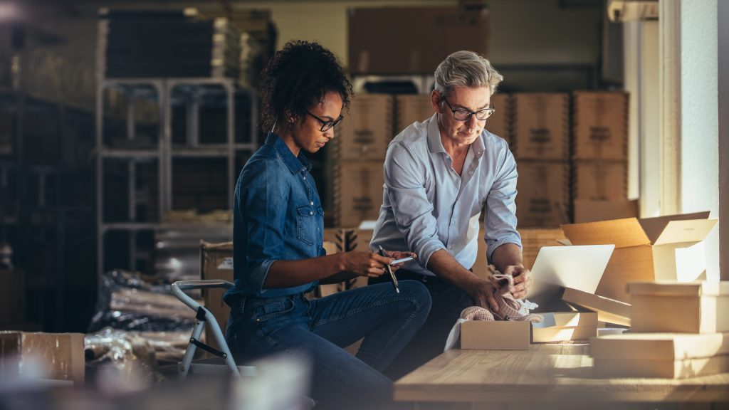 Small-business owners prepare packages for shipping, unaware of the average cost of a data breach for a small business. 