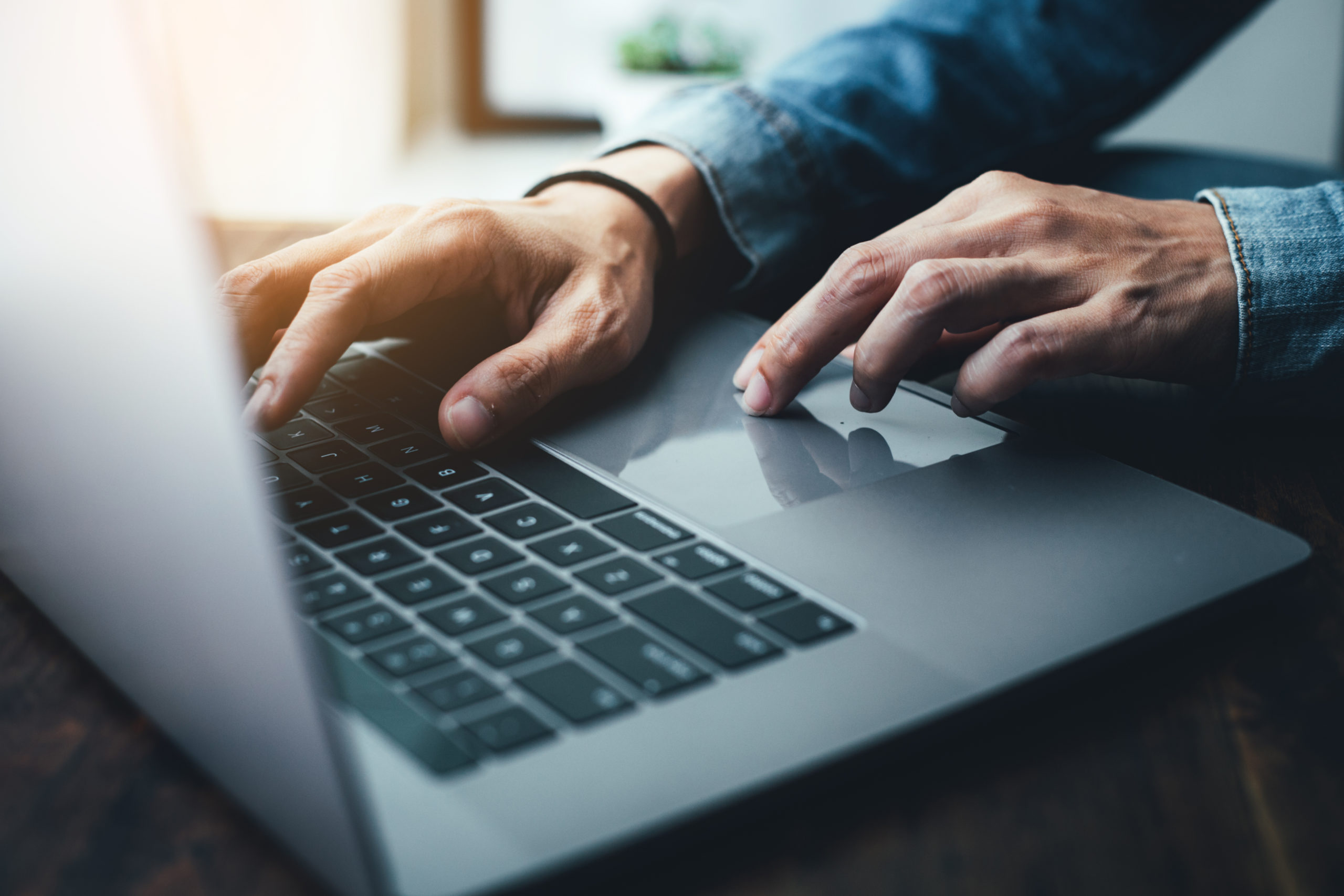 Older man hands typing on computer.