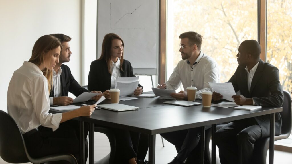 Small business’s board of directors sits around table discussing the need for Directors & Officers (D&O) Insurance.