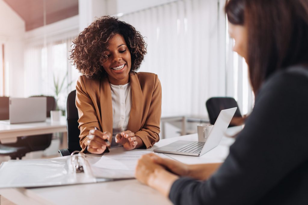An African American client consults with her female insurance professional. 