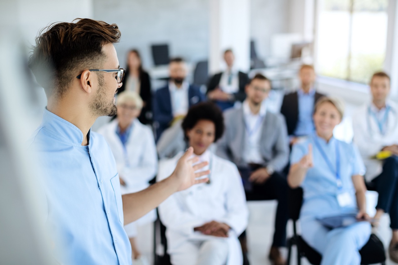 Young physician gives training session on how to respond to a cyber attack incident in a medical facility.