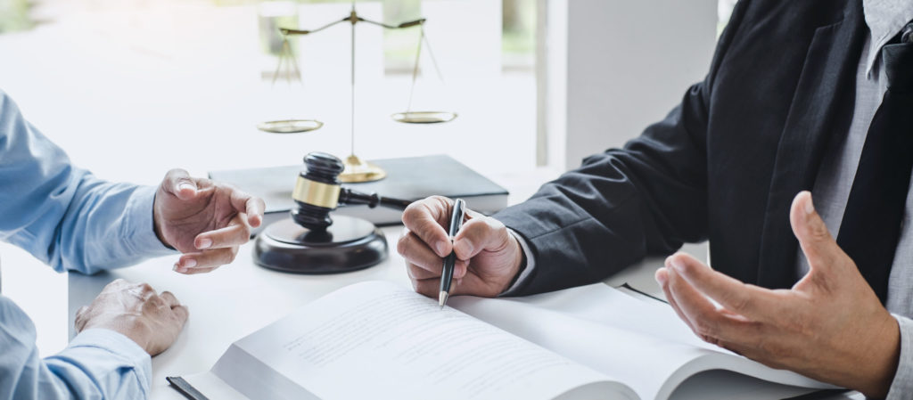 Man talking with lawyer, pointing to a book. 