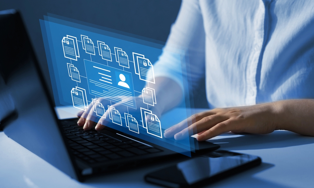 Concept image of employee extracting personal information of clients from a laptop with the help of AI software. 