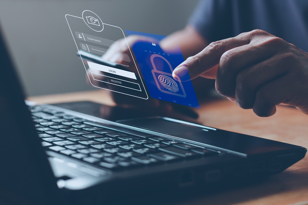 Image of male hands logging into company database using two-step verification system. 