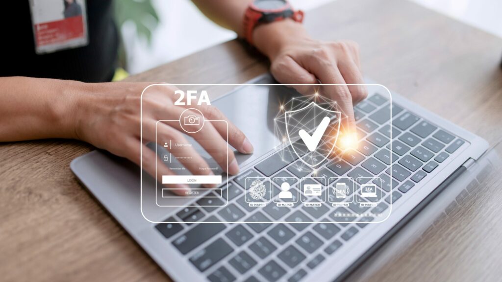  Hands typing on laptop computer keyboard overlaid with transparent graphic illustrating two-factor and multifactor authentication.