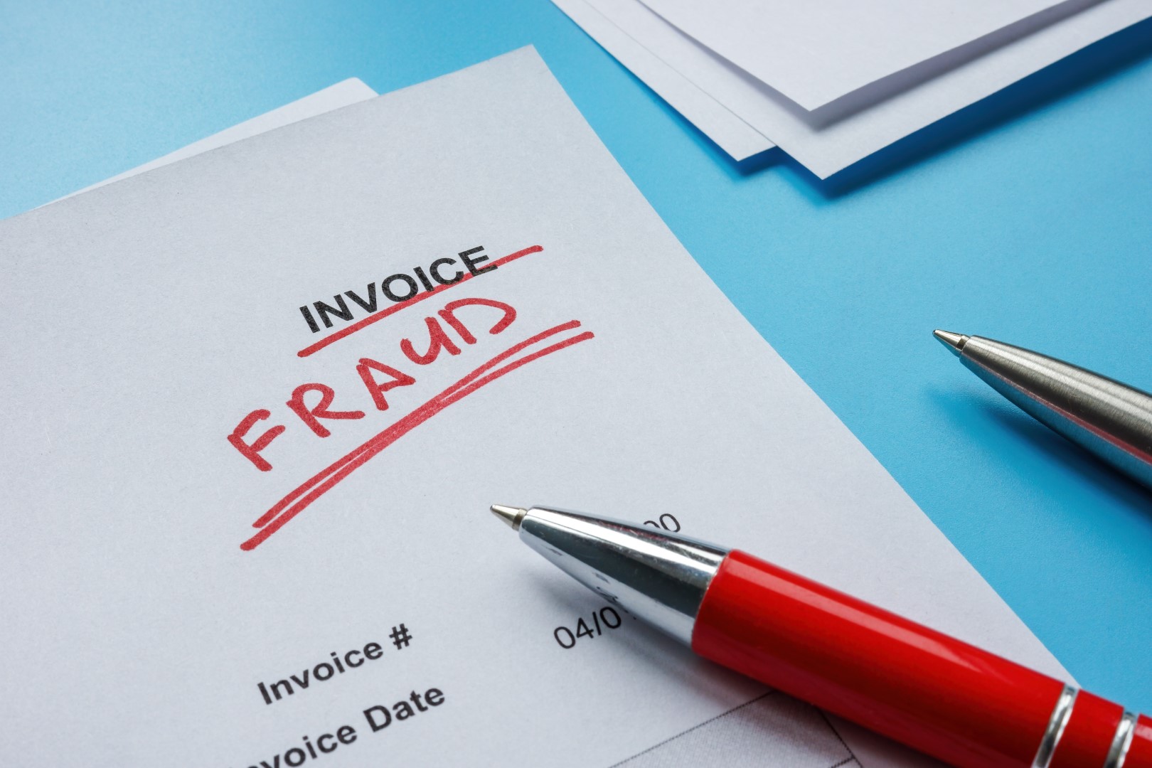 Paper invoice labeled “FRAUD” in corner. Invoice manipulation is one risk against which Cyber Insurance for contractors protects.