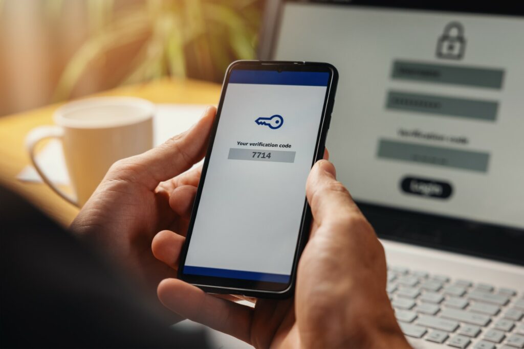 Hands enter multifactor authentication (MFA) codes to access a network.