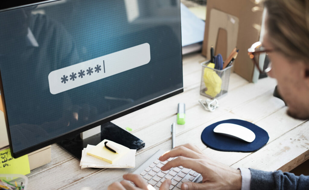 Man resets password on computer in social engineering hack.