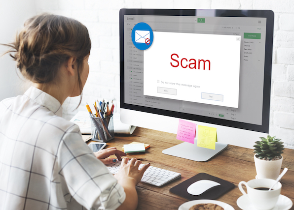 A concept image of a company employee receiving a phishing scam warning on her computer screen.