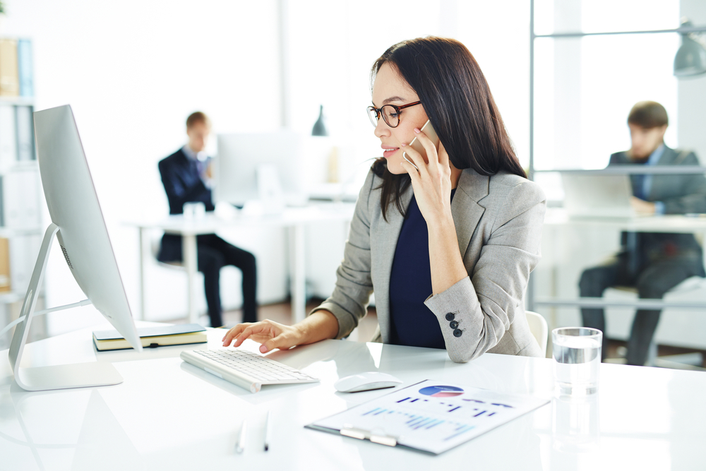 Cyber Insurance broker works from her desk to prepare a contract for a new client.