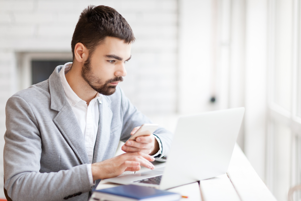 Insurance broker uses laptop to review information about the cost of a data breach to share with his business clients.
